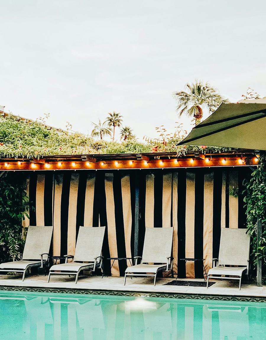 Striped poolside cabana with lounge chairs